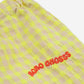 A close-up of the red embroidered "BOBO CHOSES" logo on the gingham fabric.