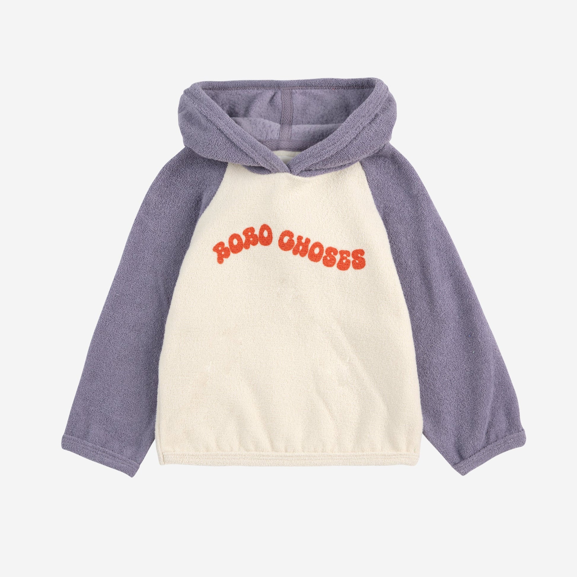 A Bobo Choses baby terry cloth hoodie with a colour-block design. The hoodie has a cream body, soft purple sleeves, and a matching hood. "BOBO CHOSES" is printed in bold, textured orange letters across the chest.