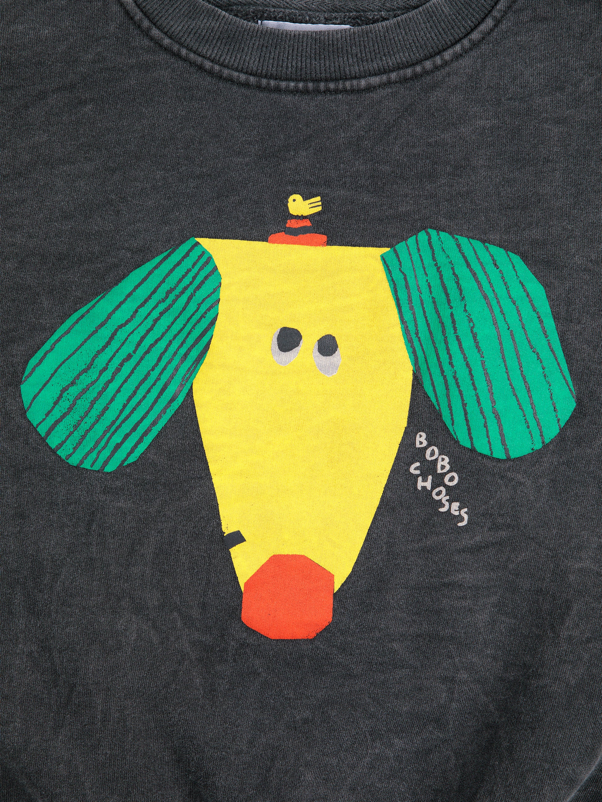 Close-up of the sweatshirt’s graphic print, showing a stylized yellow dog with green ears, an orange nose, and a small bird sitting on its head. The "BOBO CHOSES" logo is handwritten near the dog’s face.