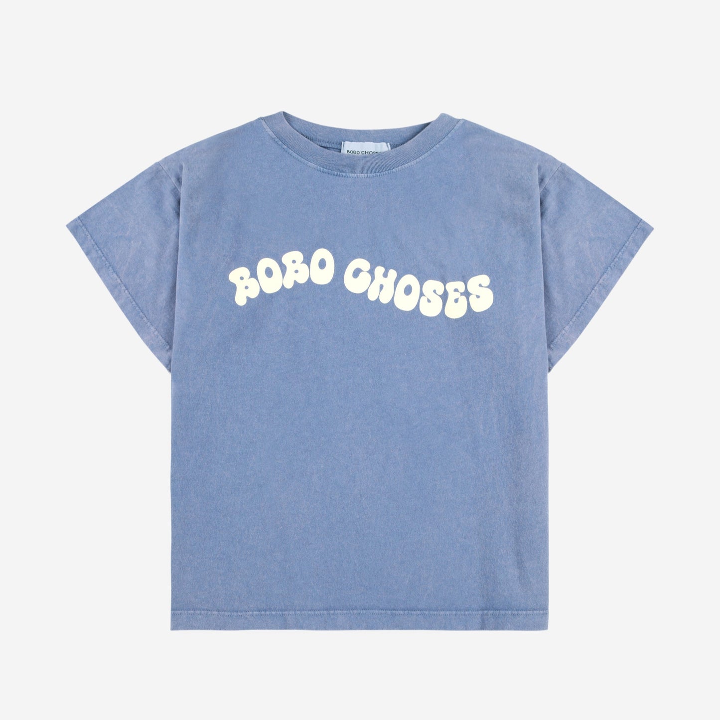 Flat-lay of a blue oversized t-shirt featuring a wavy "BOBO CHOSES" logo print in cream.