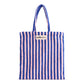 A baby pink and deep blue striped classic tote bag, made of towelling fabric with a baby pink and deep blue striped handle. At the top of the bag it says BONGUSTA in black inside of a cream box with green and lilac flowers coming off the words bongusta. 