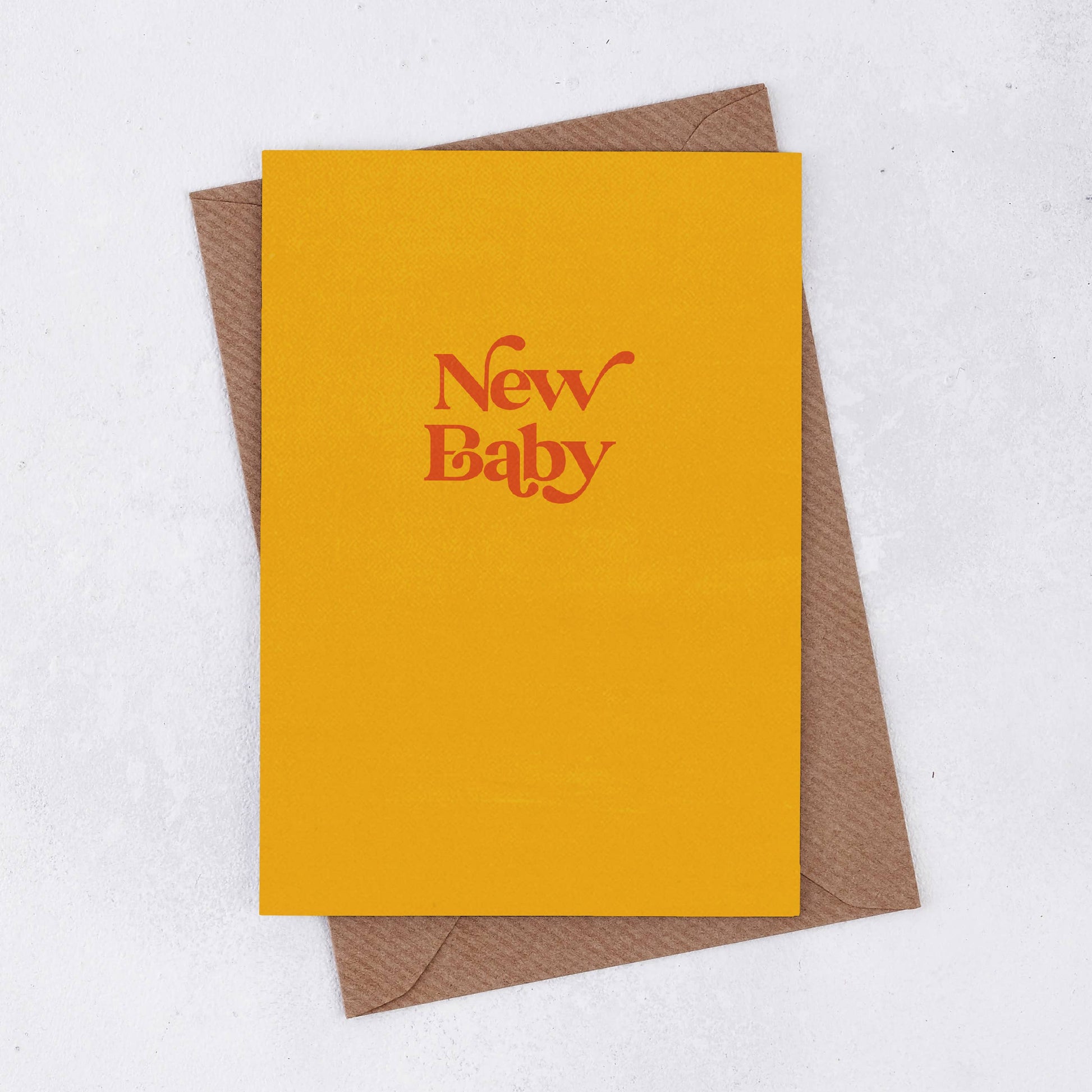 A bright yellow card with the words New Baby in red retro font. Comes with a brown Kraft envelope  