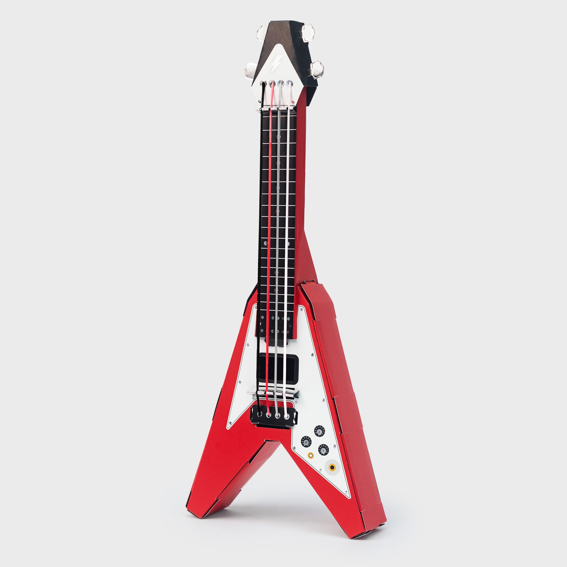 Red Build Your Own Rock Star Guitar – a playable cardboard Flying-V guitar kit featuring pop-out components that assemble without glue or tape. Elastic bands serve as strings, making it a fun DIY project for kids to create their own unique musical instrument. Perfect for imaginative play and creativity.