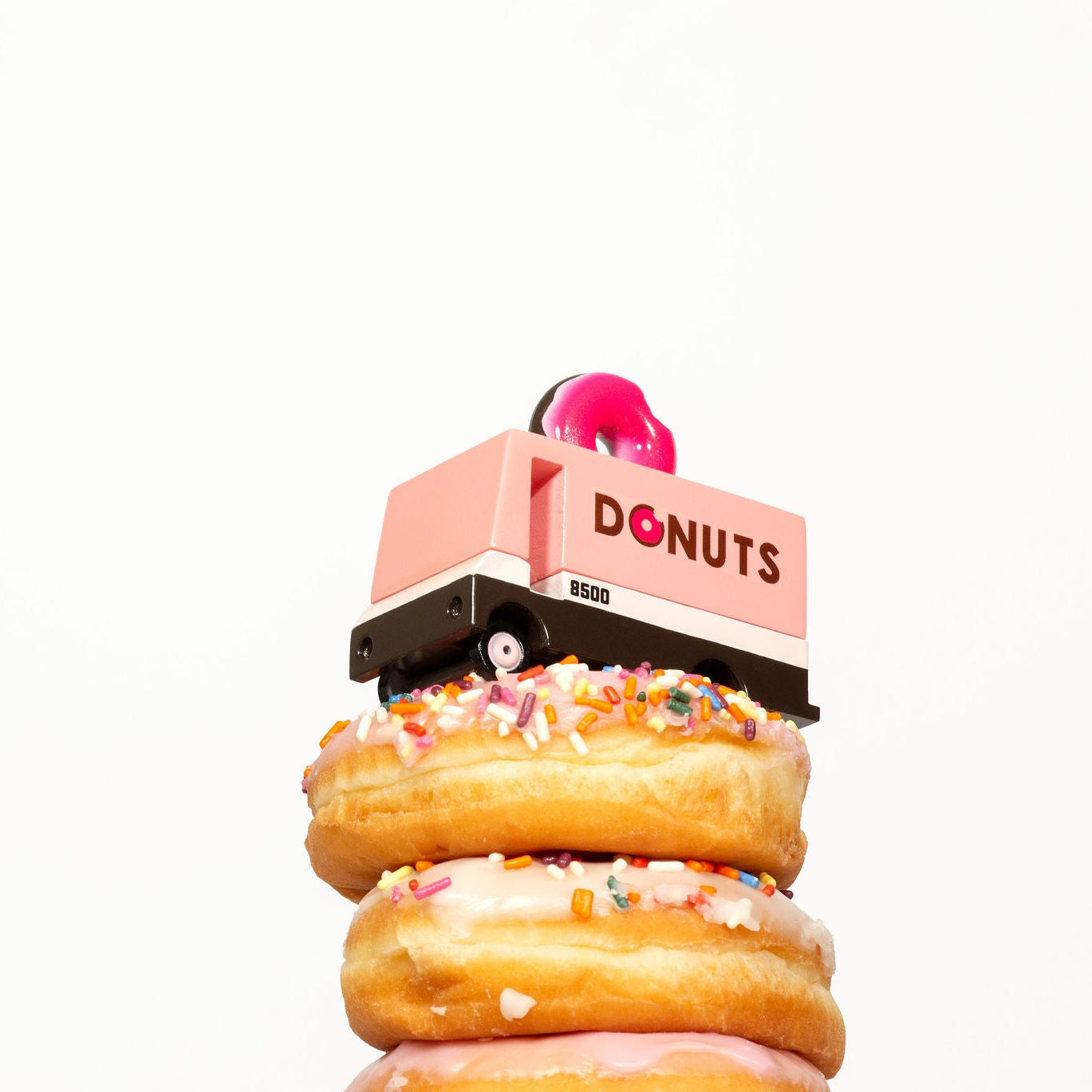 Stack of donuts with a pink 'DONUTS' box on a white background