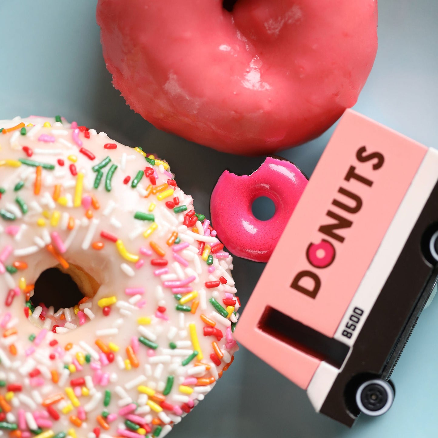 Two donuts and a 'Donuts' tape cassette on a light blue plate.