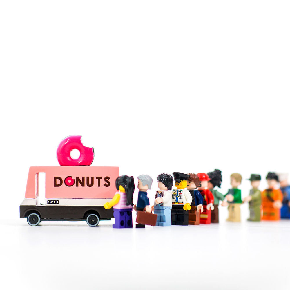 Model of a 'Donuts' truck with a line of small figures in front on a white background