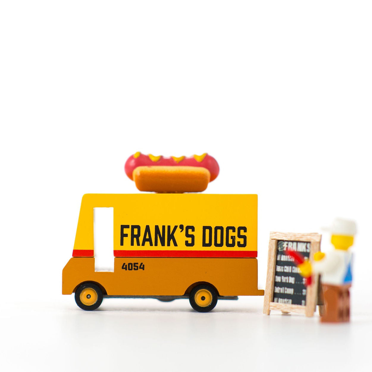 Toy hot dog cart with 'Frank's Dogs' branding on a white background