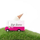 Model of a pink ice cream truck with an ice cream cone on top, labeled 'Soft Swerve', on a grassy surface.