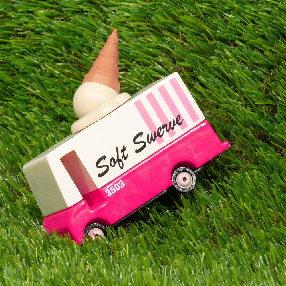 Toy ice cream truck with a cone on a grassy background