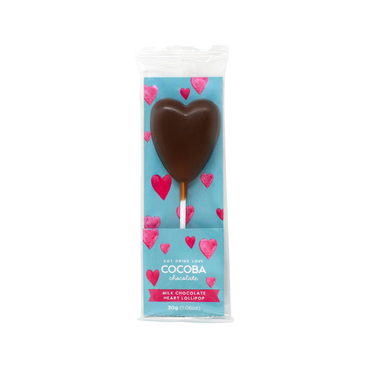 A milk chocolate lollipop in the shape of a heart on a white stick in a cellophane bag with a card insert that is blue with pink hearts printed all over it 