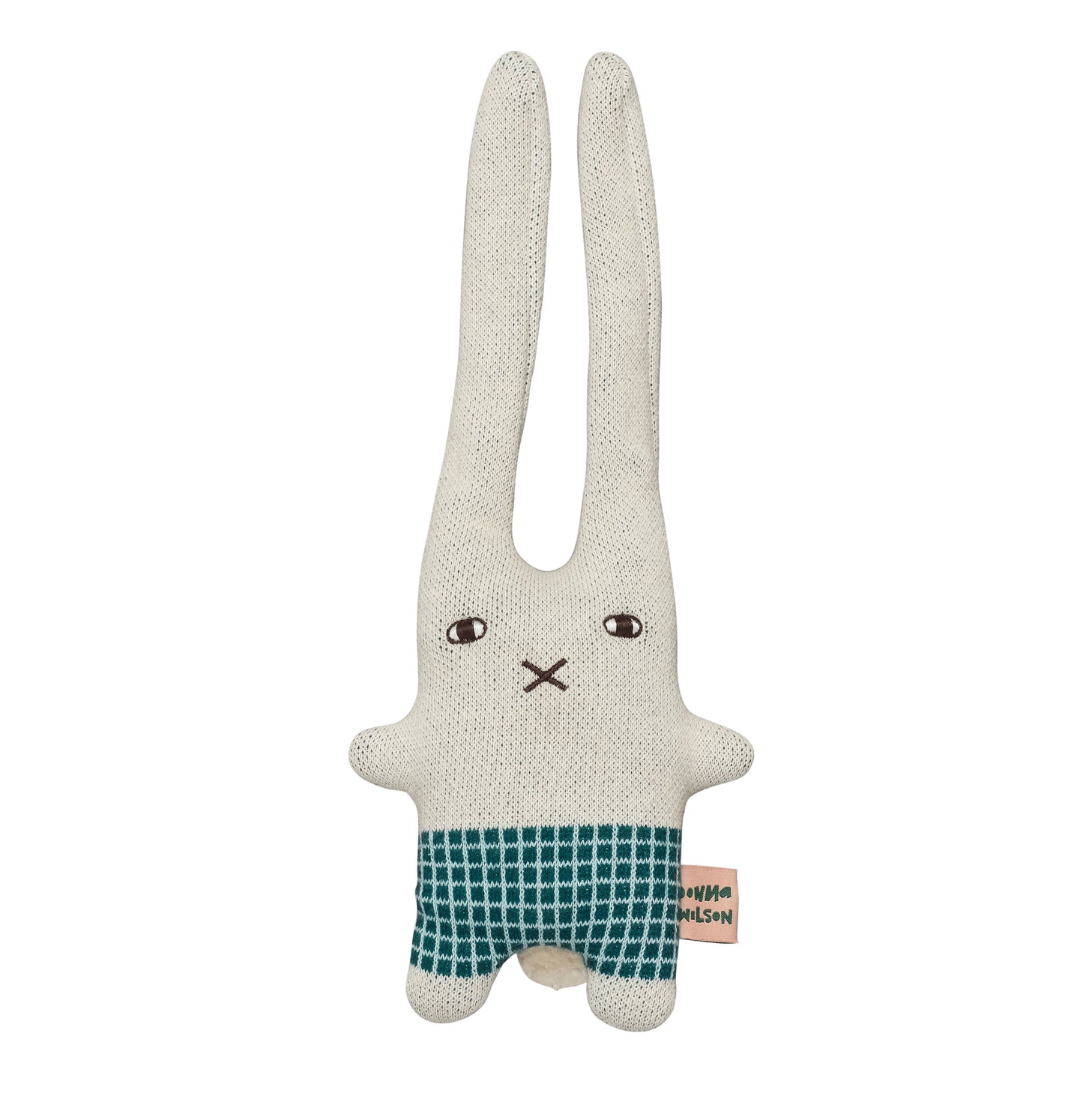 Donna Wilson knitted wool bunny in a naive illustration style. It has a square body with green check shorts and short little arms and feet, with two extra long ears. A little embroidered cross nose and white and black eyes, on a light grey base. And a pink with green lettering label spelling Donna Wilson