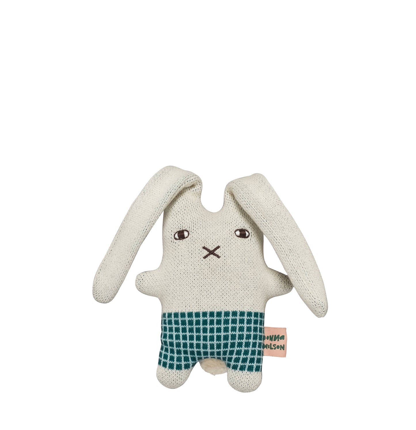 Donna Wilson knitted wool bunny in a naive illustration style. It has a square body with green check shorts and short little arms and feet, with two extra long ears. A little embroidered cross nose and white and black eyes, on a light grey base. And a pink with green lettering label spelling Donna Wilson