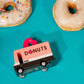 Toy donut truck with 'DONUTS' on a turquoise background with real donuts.