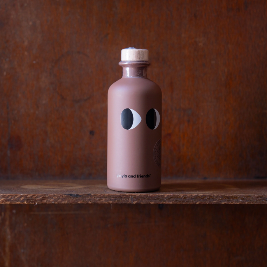 Brown bottle with black and white design on a wooden surface and brown background