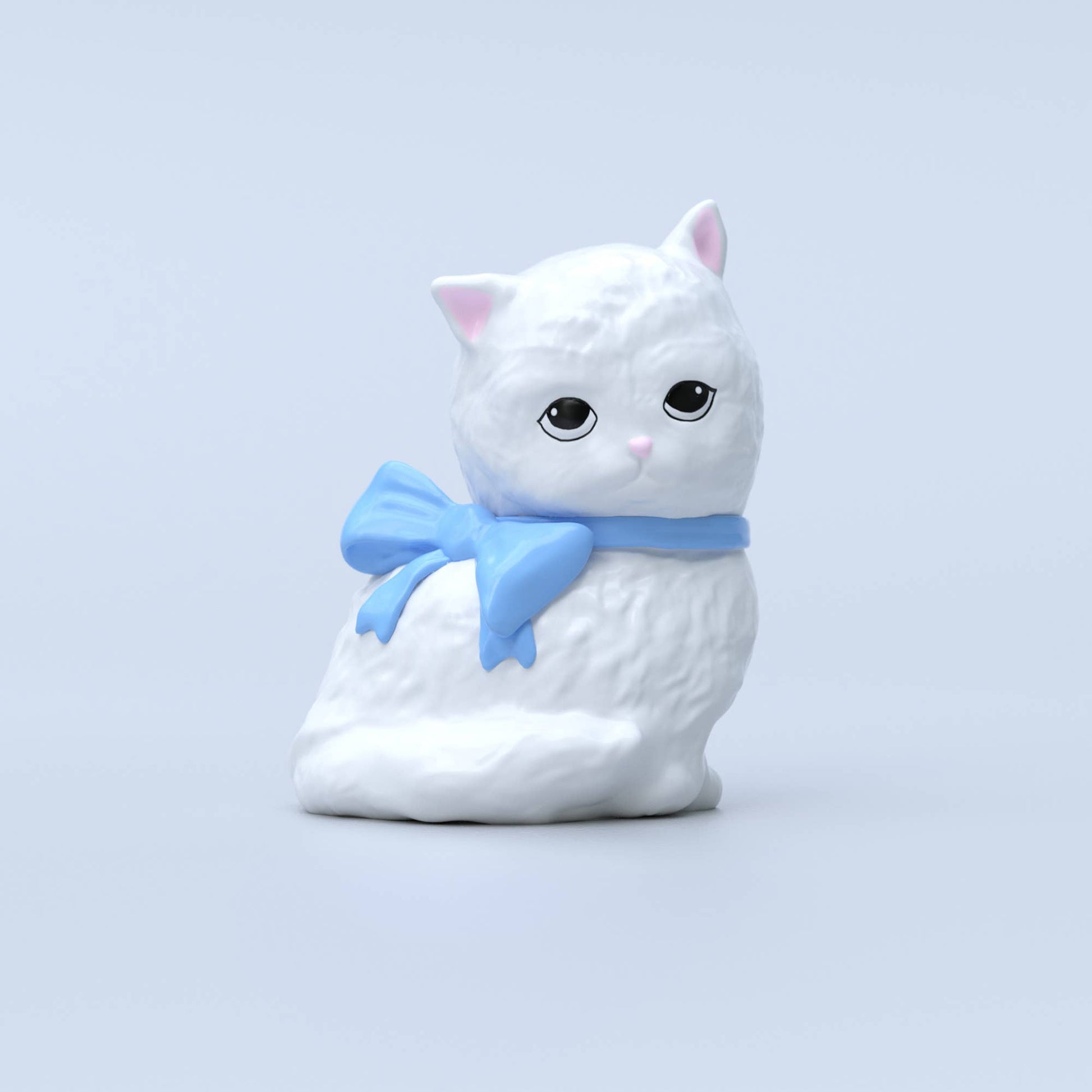 A standalone image of the white ceramic cat vase with a glossy finish and a soft blue bow, against a light blue background.