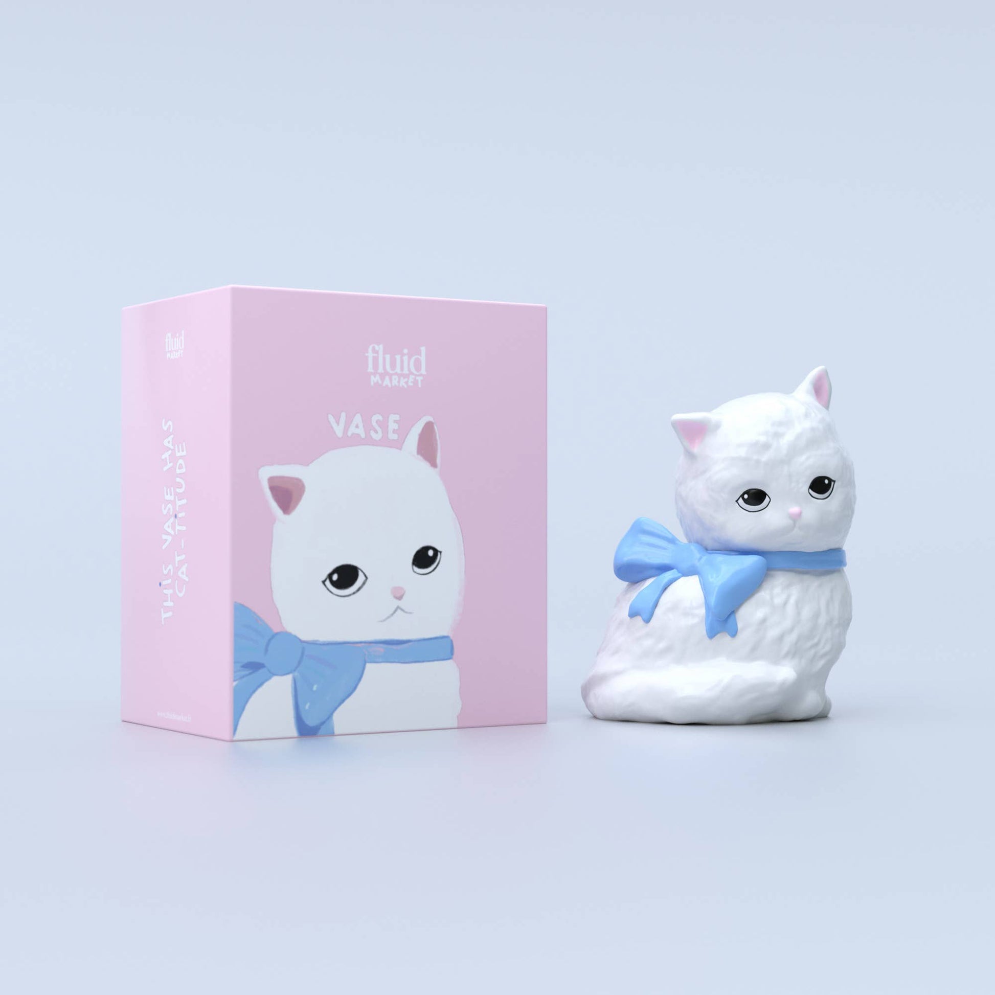 A white ceramic cat-shaped vase with a blue bow sits beside its pastel pink packaging, which features an illustrated cat with the text “This vase has cat-titude.”