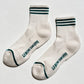 White socks with black text 'LEBON SHOPPE' on a light gray background