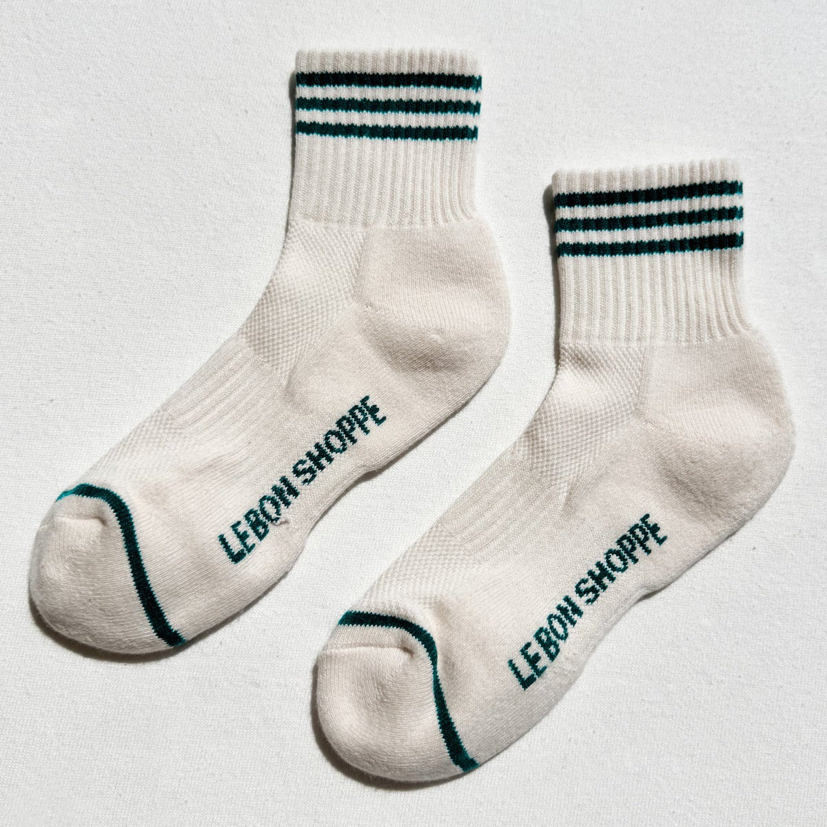 White socks with black text 'LEBON SHOPPE' on a light gray background