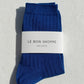 Pair of blue socks with a white label on a light gray background