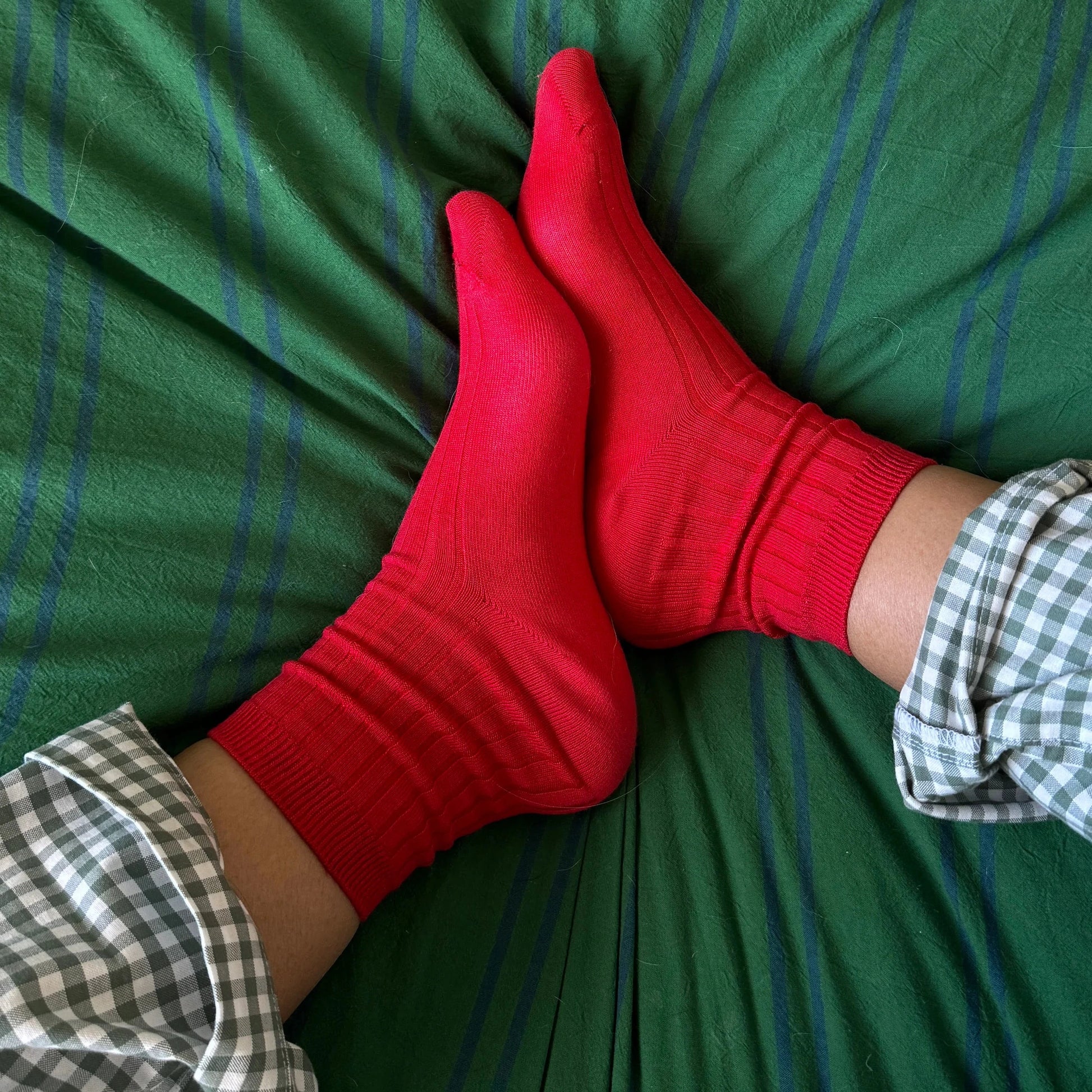 Red socks on a green bedspread