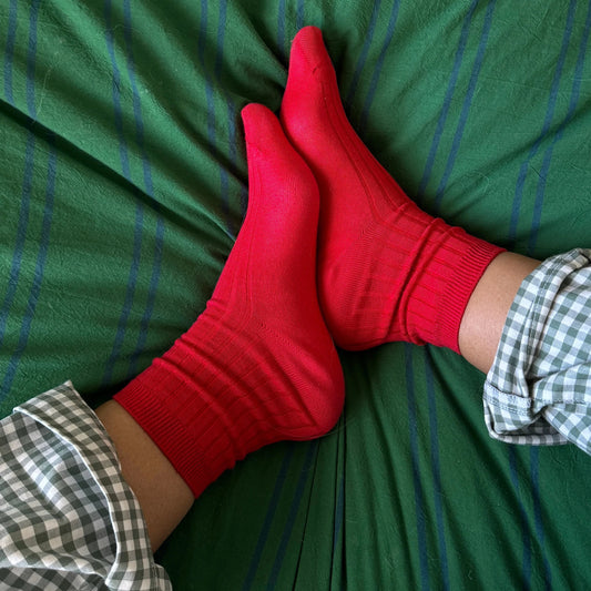 Red socks on a green bedspread