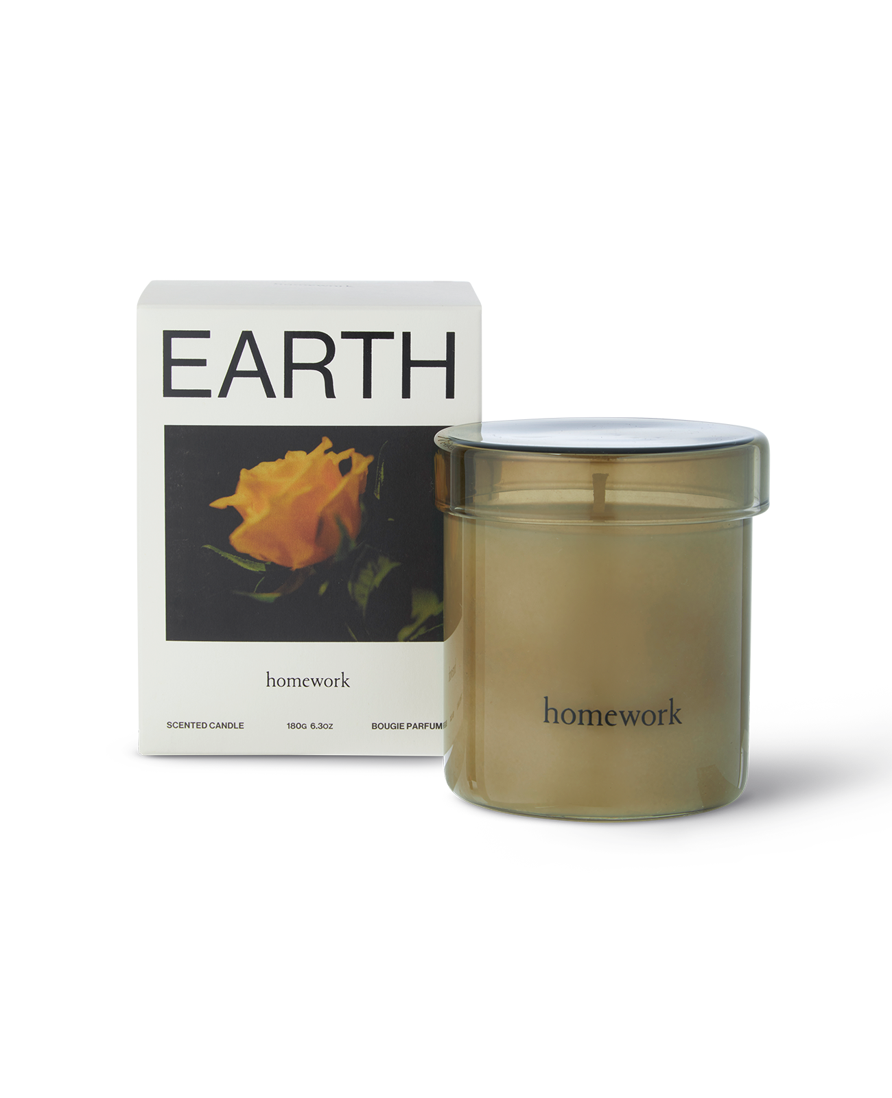 Homework candle in scent Earth. A translucent green glass with lid around the candle the size of a mug with minimal branding reading homework in lower case. Next to the packaging a white box reading Earth at the top and a landscape photograph of an orange rose and the brands name homework under the image