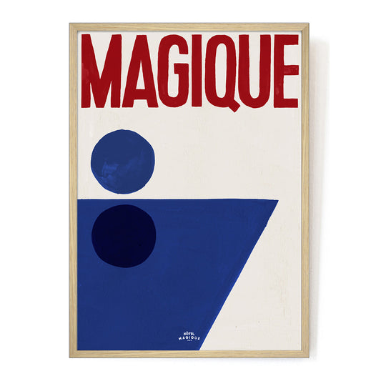 This A3 Hotel Magique print titled 'A Splash Of Magigue' features a white background, a royal blue circle, a navy blue circle and a royal blue triangular shape. The text "Magique" is written in deep red. "Hotel Magique" is written in white in a small font. The print frame is wooden.