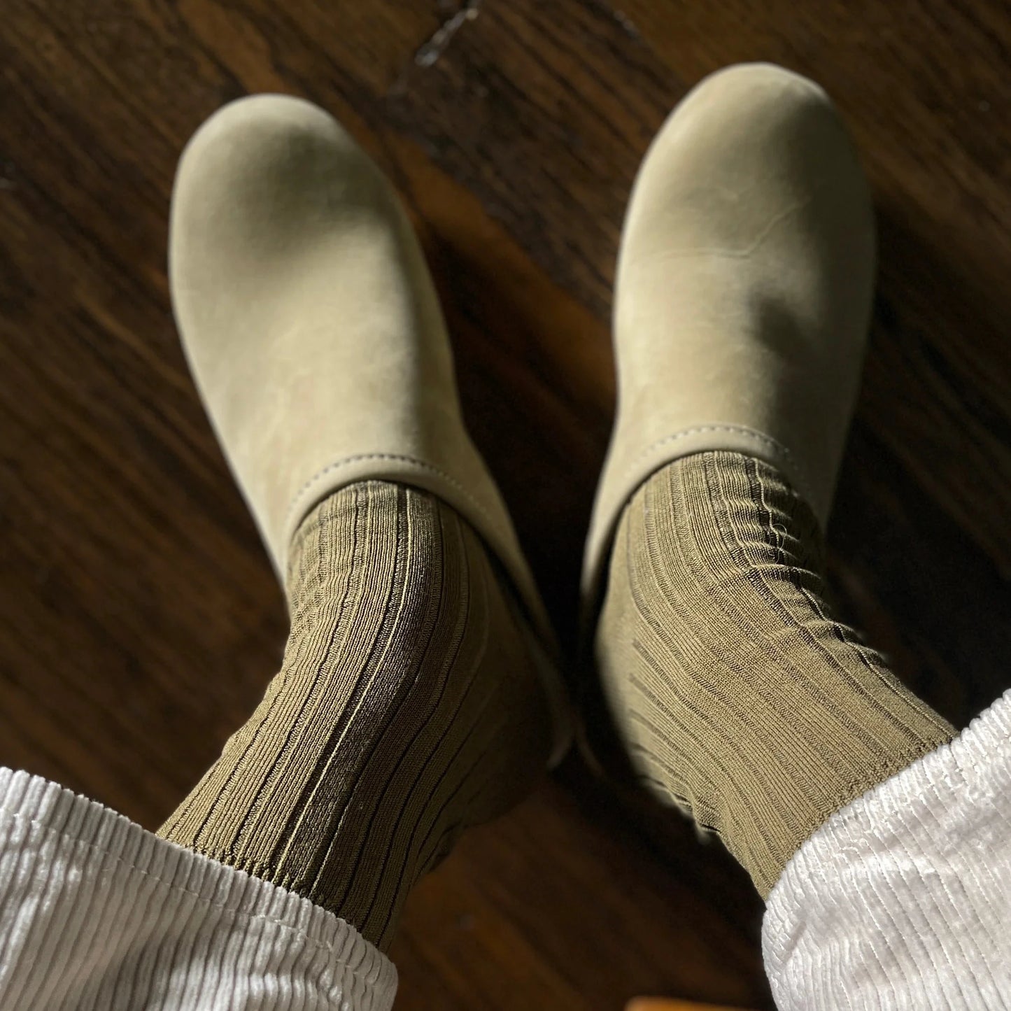 Beige shoes and socks on a wooden floor