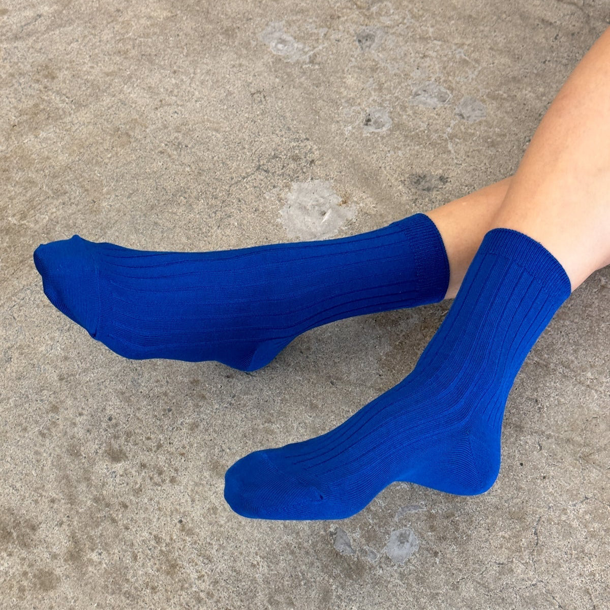 Blue socks worn on a concrete surface