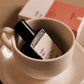 Small bottle labeled 'culot the' in a white cup with a blurred background