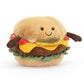 A plush toy in the shape of a cheeseburger. The bun has a smiling face and two black eyes, which appear to be small beads. The bun also has two short brown arm coming out of it. Between the beige buns are the layers of a burger, that being red tomato, yellow cheese, a brown patty and green lettuce. This is against a white background. 