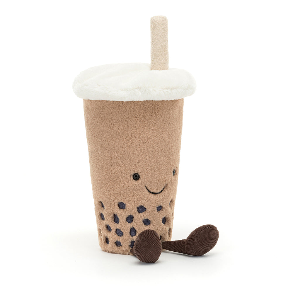 Soft Jellycat Amuseable Bubble Tea plush toy with a smiley face, fuzzy straw, corduroy legs, and velvety boba balls in a beige cup. Shown from the left hand side