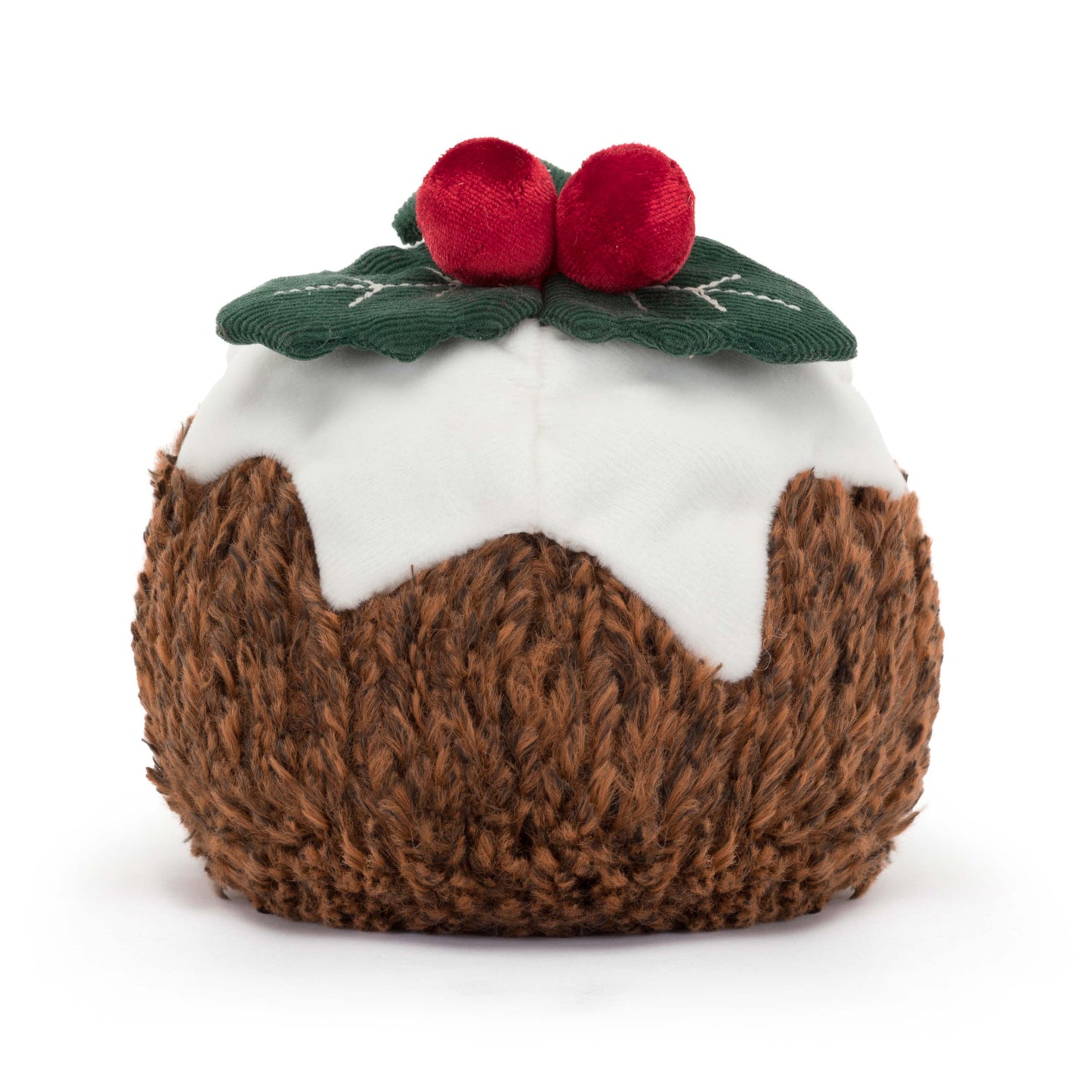 A plush Jellycat Amuseables Christmas Pudding with a textured brown body, white icing drizzle, two red berries, and a green leaf, sitting on a white surface. Shown from the back