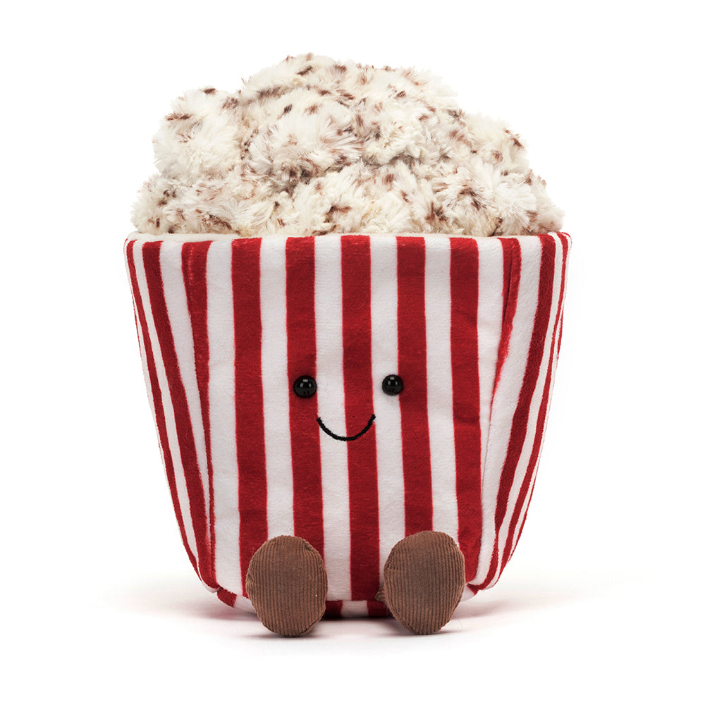 A whimsical Jellycat Amuseables Popcorn plush toy featuring a red-and-white striped tub with a smiling embroidered face, overflowing with fluffy, buttery popcorn pieces on top, and playful brown corduroy legs. Perfect for movie night vibes.