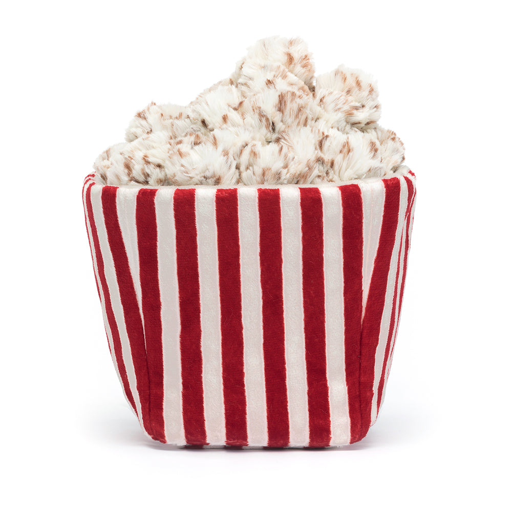 Rear view of A whimsical Jellycat Amuseables Popcorn plush toy featuring a red-and-white striped tub with a smiling embroidered face, overflowing with fluffy, buttery popcorn pieces on top, and playful brown corduroy legs. Perfect for movie night vibes.