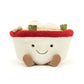 A quirky Jellycat Amuseables Ramen plush toy featuring a soft white bowl with a cheerful embroidered face, fluffy noodles spilling over the top, and vibrant plush toppings like an egg, seaweed, and a slice of pink swirl fish cake. Complete with corduroy legs for extra charm.