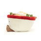 Side view of A quirky Jellycat Amuseables Ramen plush toy featuring a soft white bowl with a cheerful embroidered face, fluffy noodles spilling over the top, and vibrant plush toppings like an egg, seaweed, and a slice of pink swirl fish cake. Complete with corduroy legs for extra charm.