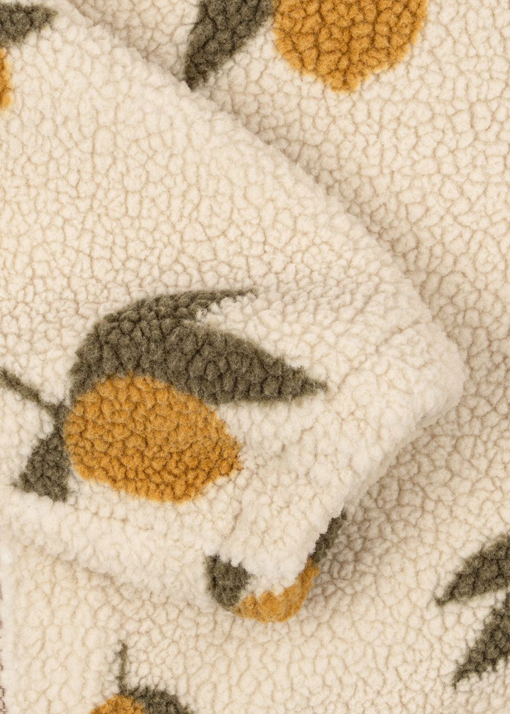 Close-up of the Konges Sløjd Mon Grand Citron Jody Jacket's fabric – A detailed look at the soft sherpa fleece texture with a yellow lemon and green leaves woven into the fabric.