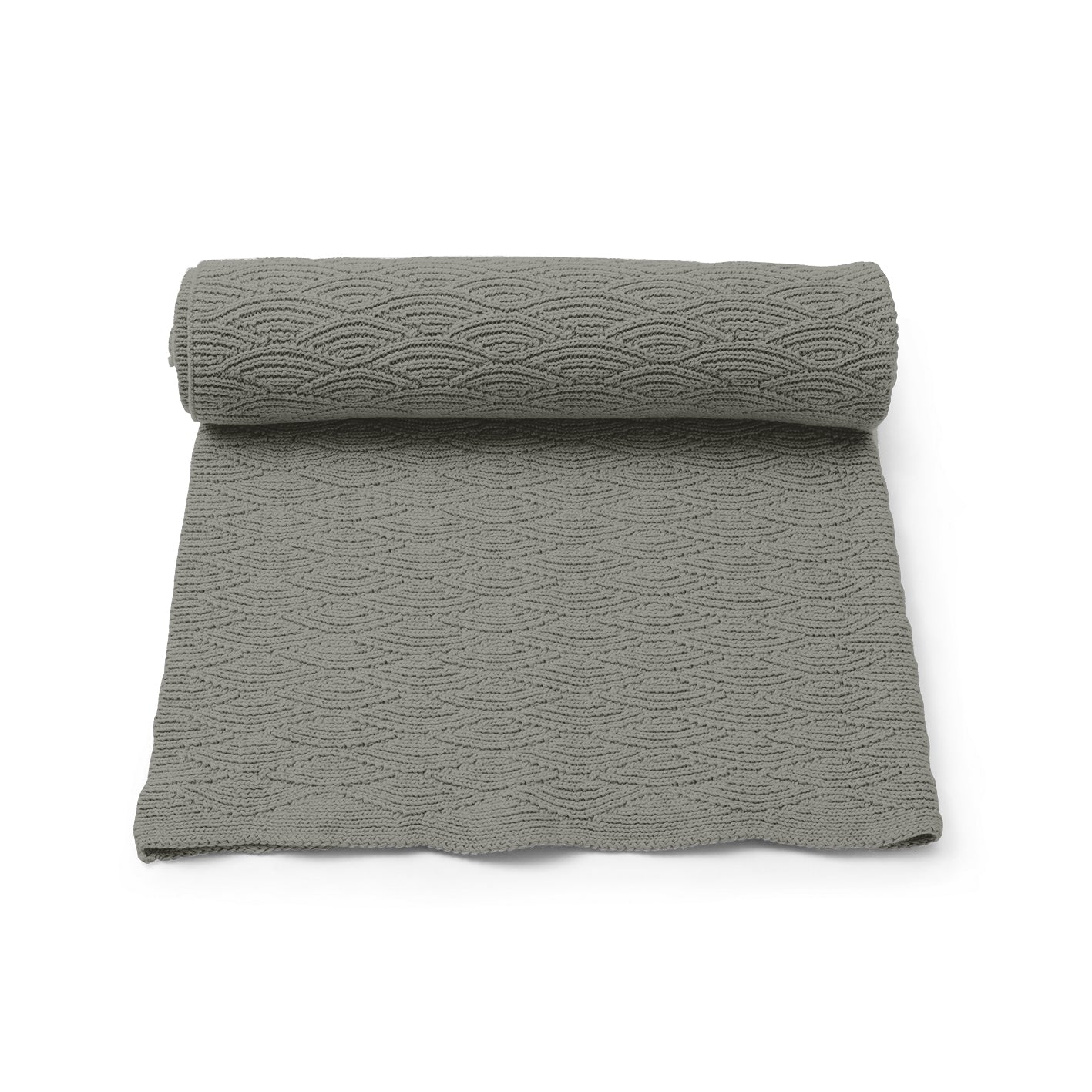 The Konges Sløjd Mulled Basil Pointelle Blanket, rolled up and partially unrolled, showcasing its delicate knit pattern in a muted green shade.