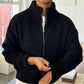 Person wearing a black zip-up sweater indoors