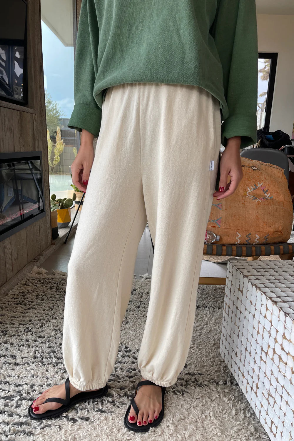 Le Bon Shoppe Balloon Pants in Natural, styled with a green top – Relaxed cotton sweatpants with an elasticated waist and gathered cuffs, paired with a long-sleeve top for an effortless, cosy look.