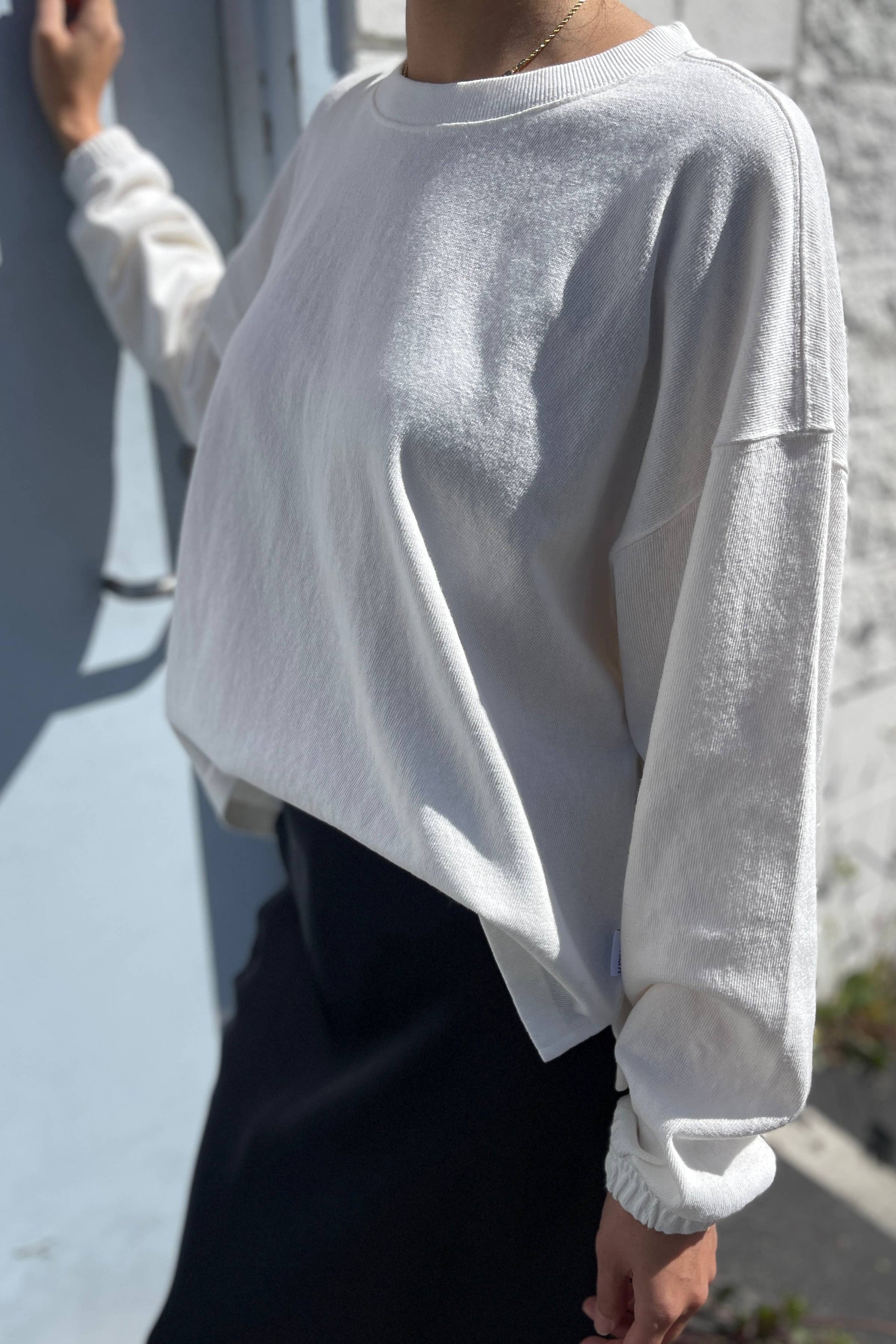 Close-up of the Le Bon Shoppe Naturelle Tee in Natural, worn outdoors. The relaxed fit, heavyweight cotton texture, and ruched sleeve detail are highlighted in natural light.