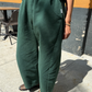 Person wearing green pants standing on a sidewalk