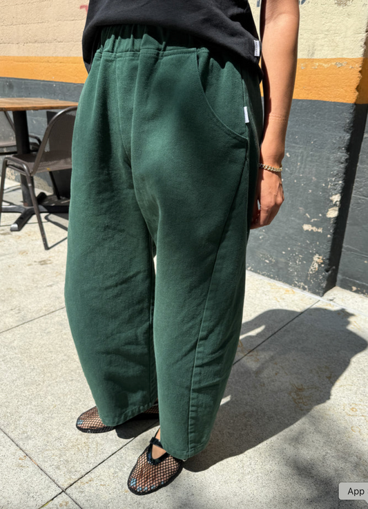 Person wearing green pants standing on a sidewalk