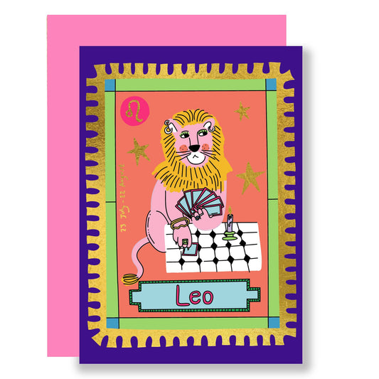 Lion wearing piercings and rings, playing a game of cards against a pink background with a gold foil trim.