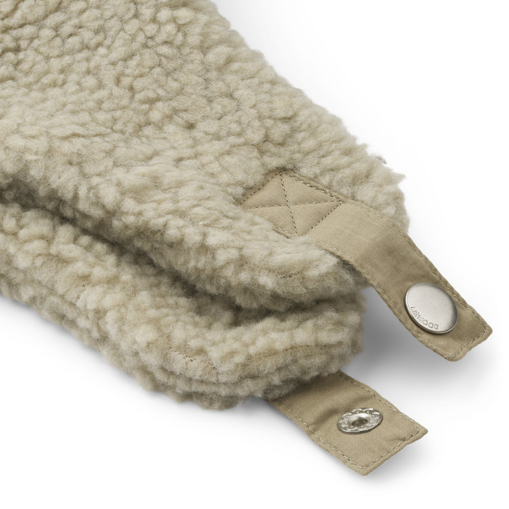 A close up of the Liewood mist Bravo Pile Hat for children, featuring soft fleece lining, protective earflaps, and adjustable snap-button straps, displayed on a neutral background.