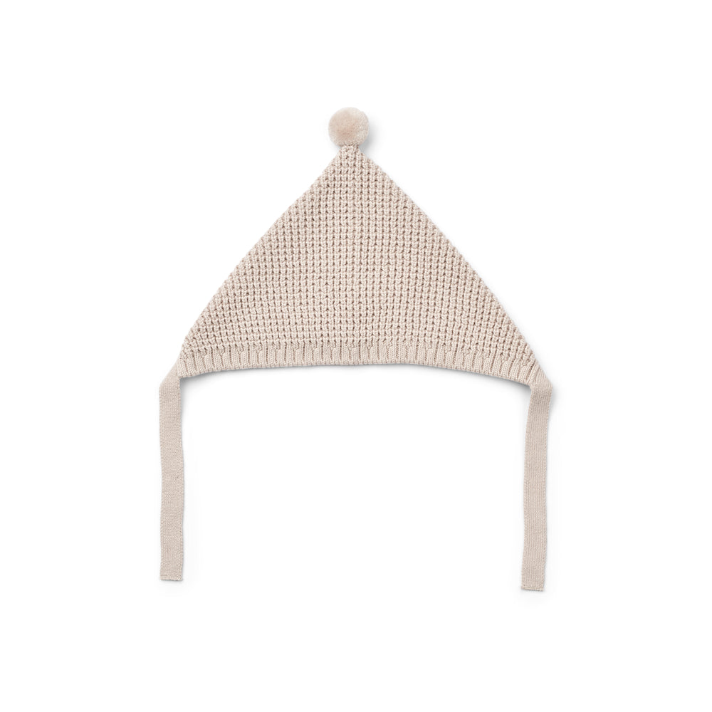 Liewood Fresia Baby Hat in Sandy, featuring a playful pompom on top, long adjustable strings, and delicate organic cotton knit