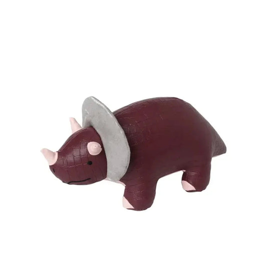 Side view of Penelope the Triceratops dinosaur toy, showing its maroon crocodile-textured vegan leather, pink accents, and shimmering silver frill detail