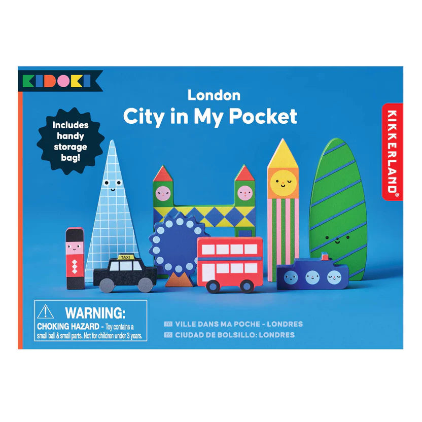 "London City In My Pocket wooden toy set packaging. The box features a blue background with illustrated wooden blocks representing iconic London landmarks, including Big Ben, the London Eye, Tower Bridge, a black taxi, and a red double-decker bus. A label highlights the included storage bag. A warning label notes small parts, not suitable for children under 3 years