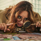 Woman with magnifying glass and spyglass examining a puzzle